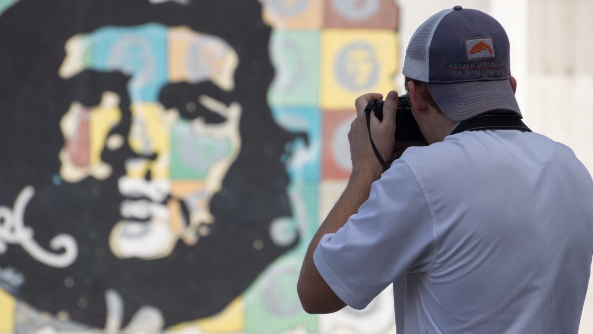 Man takes photo of Che Guevara mural in 古巴.