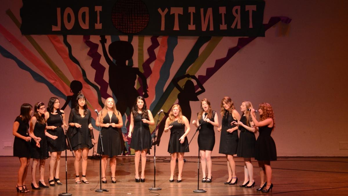 11名身穿黑色礼服的女歌手在舞台上为“澳门金沙线上赌博官网偶像”表演.